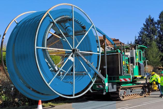 Touret de PE100 Pré-enrubanné sur trancheuse avec un geo textile bleu pour réseau d'adduction d'eau potable